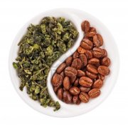 9506747-green-leaf-tea-versus-coffee-beans-in-yin-yang-shaped-plate-isolated-on-white